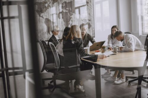 Business colleagues discuss documents around a conference table