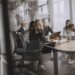 Business colleagues discuss documents around a conference table