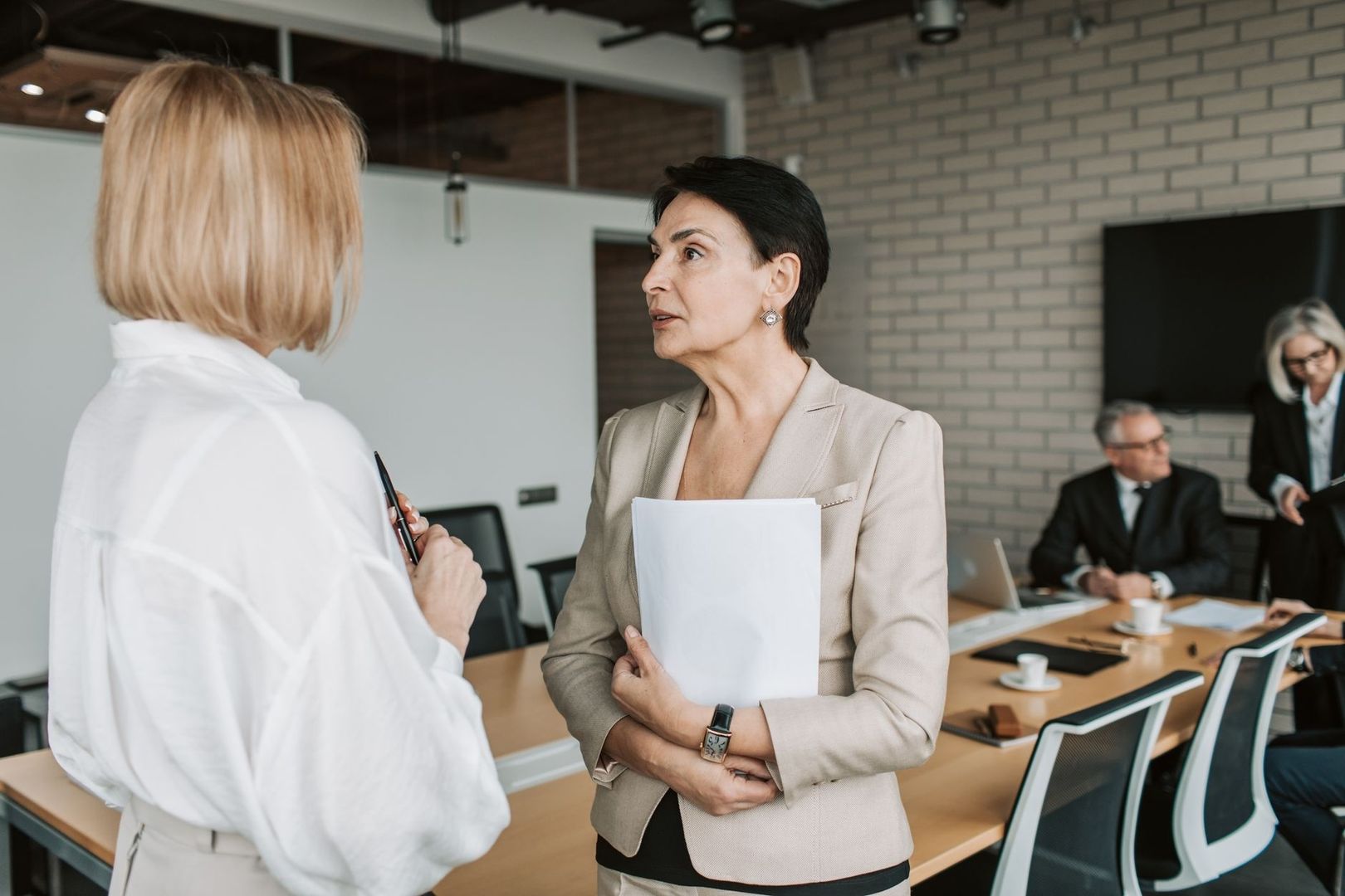 Business leaders discuss documents during a corporate meeting